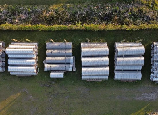 Drone shot of large aluminum pipes stacked outdoors in New Bern, NC.