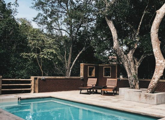 two lounge chairs near swimming pool
