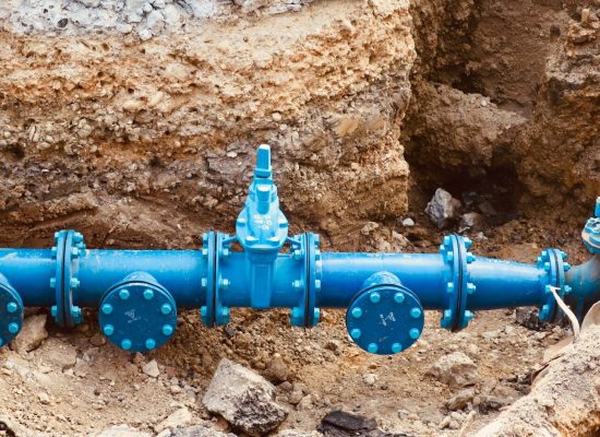 a blue pipe laying on top of a pile of dirt
