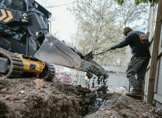 a man using a machine to lift a tree