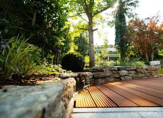 A wooden deck surrounded by rocks and trees